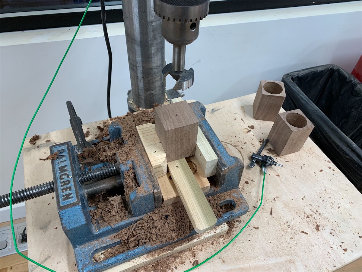 clamped wood under a drill press