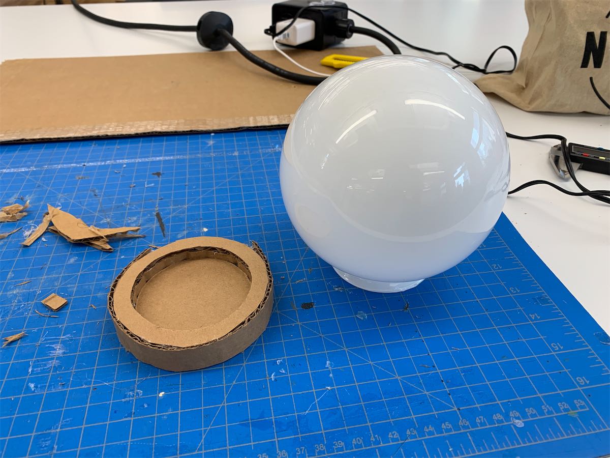 glass globe shade next to a cardboard base